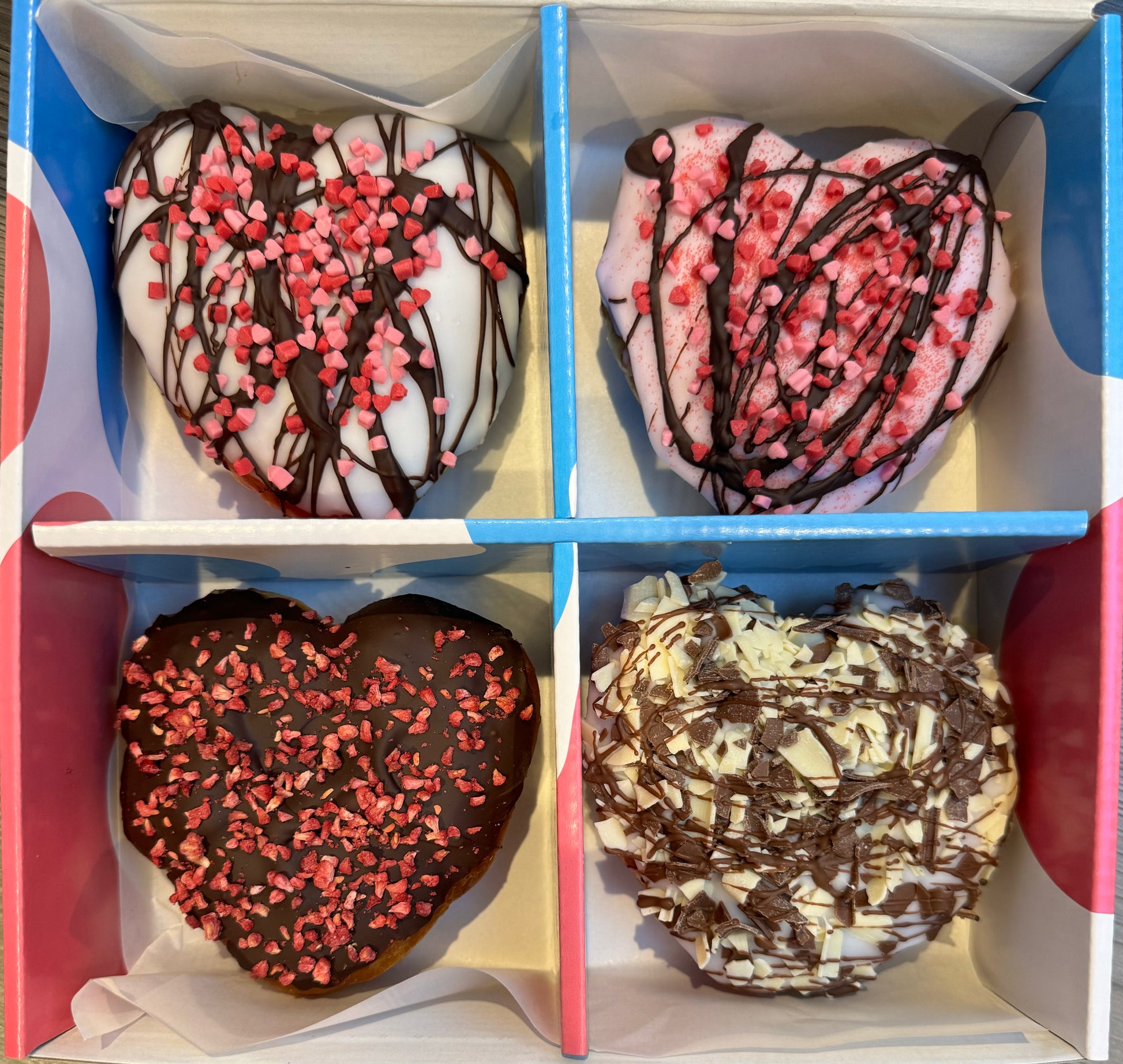 A box of colourful Valentine's themed doughnuts